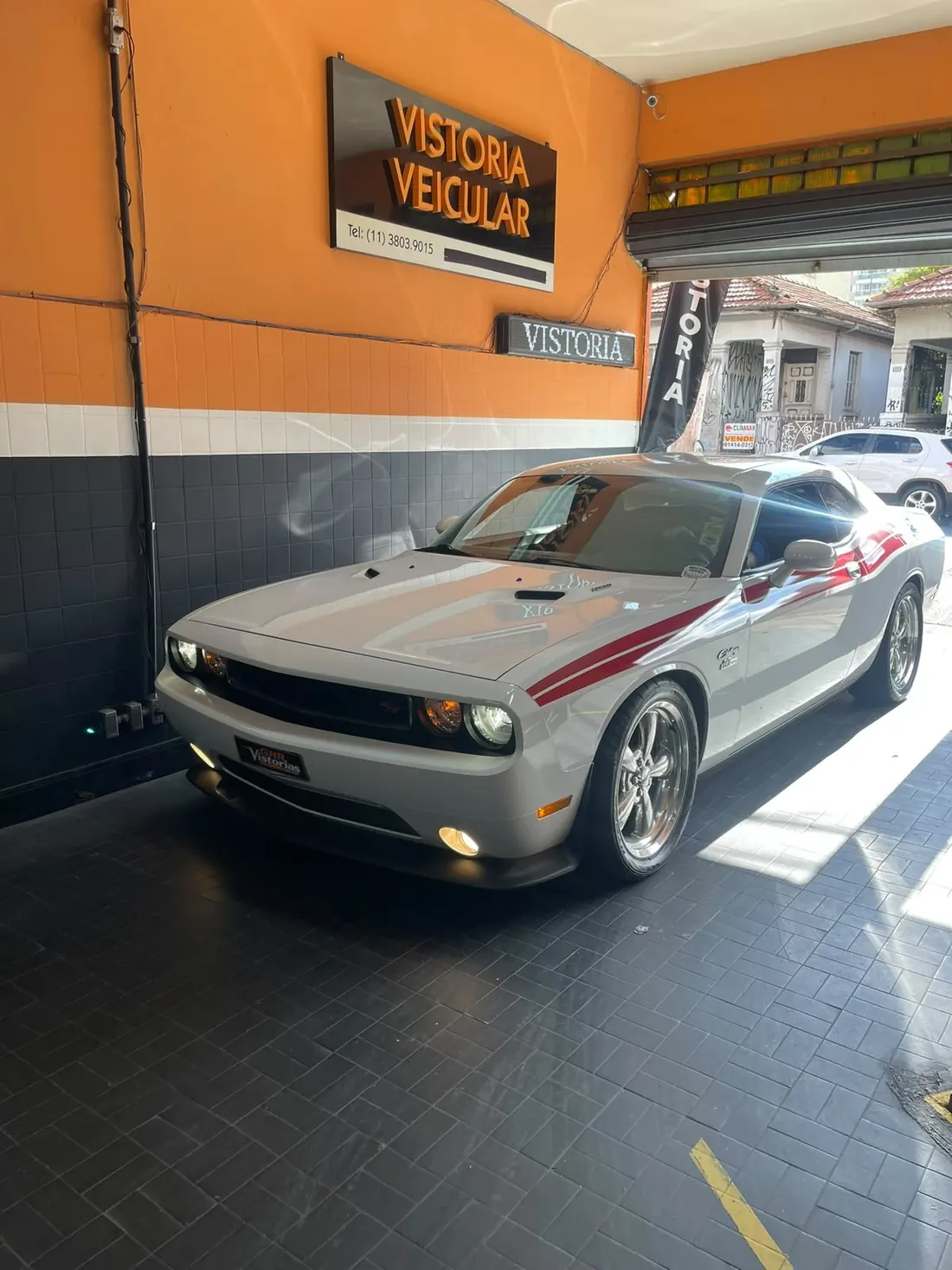 Dodge Challenger prata na área de vistoria da GHR, com a placa Vistoria Veicular ao fundo